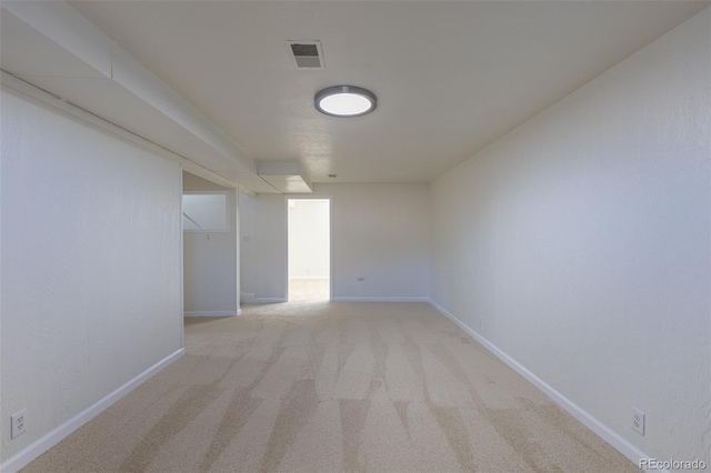 empty room with visible vents, light colored carpet, and baseboards