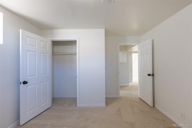 unfurnished bedroom with visible vents, baseboards, a closet, and light carpet