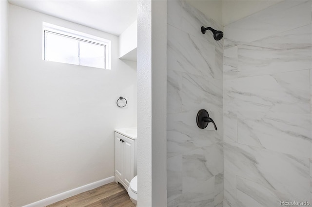 bathroom with a shower, baseboards, wood finished floors, and vanity