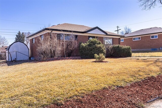 view of front of property featuring brick siding, a front yard, and fence