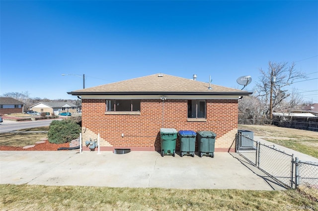 back of property with fence, brick siding, a patio, and a gate