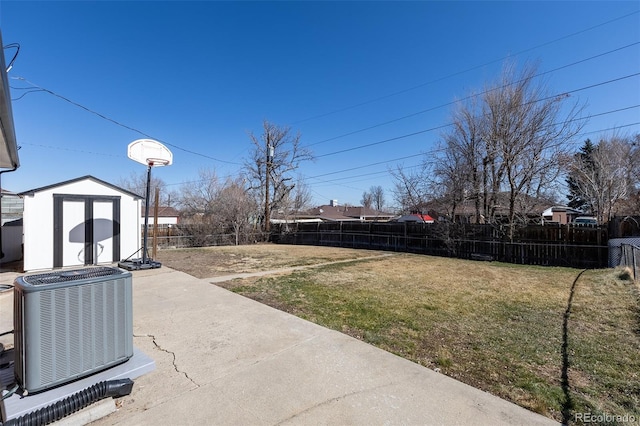 view of yard featuring a storage shed, an outdoor structure, fence, and central AC