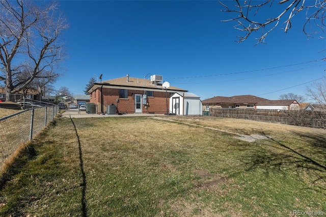 view of yard featuring an outdoor structure, central AC, a fenced backyard, and a patio area