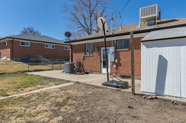 back of property featuring a patio, fence, central AC unit, and brick siding