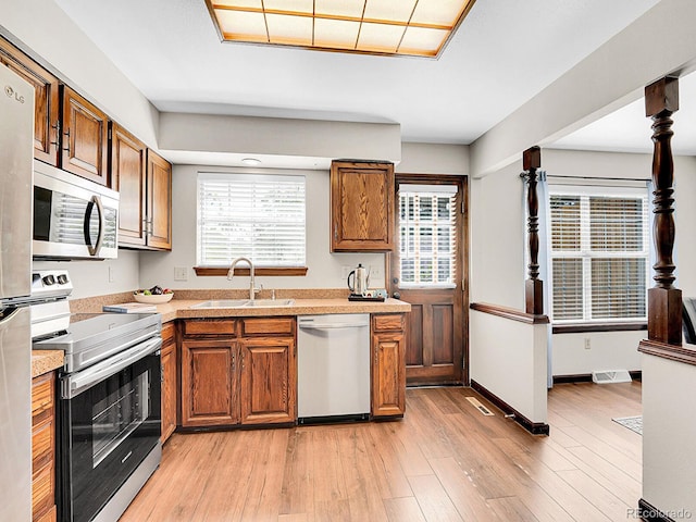 7391 S Knolls Way, Centennial, CO 80122 - kitchen featuring stainless steel appliances, light countertops, brown cabinets, and light wood-style flooring