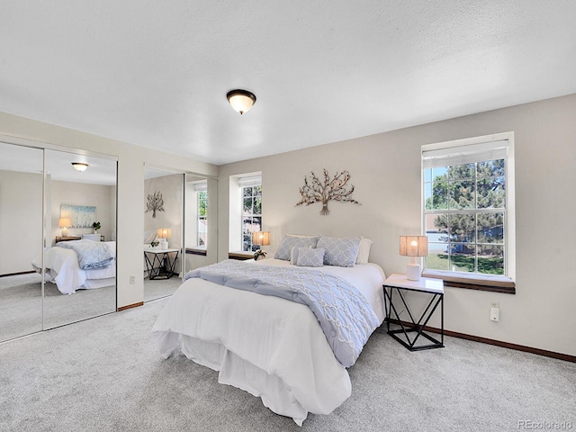 7391 S Knolls Way, Centennial, CO 80122 - bedroom featuring carpet floors, multiple windows, two closets, and a textured ceiling