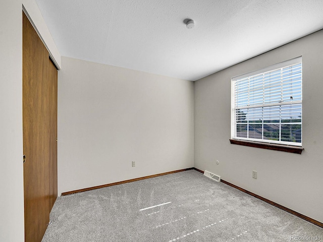 7391 S Knolls Way, Centennial, CO 80122 - unfurnished bedroom featuring carpet flooring, a closet, and a textured ceiling