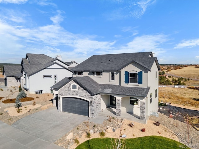 view of front of home with stucco siding, stone siding, covered porch, and concrete driveway