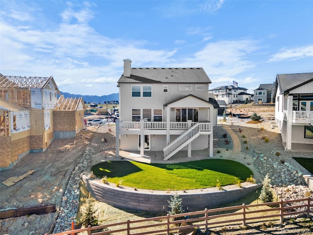 back of house featuring stairway, stucco siding, a yard, and fence