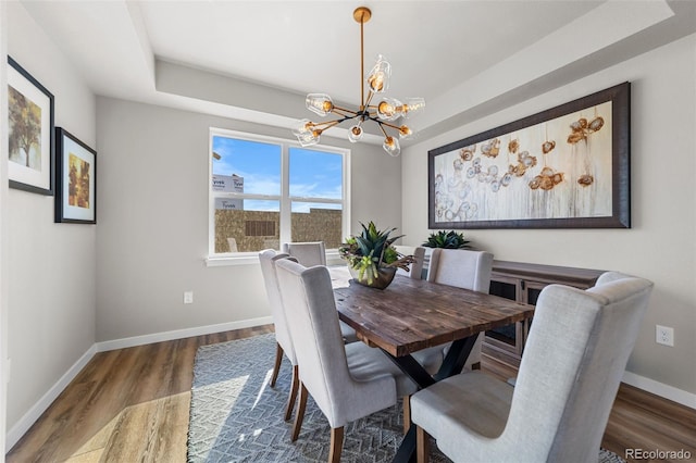 dining room with baseboards, an inviting chandelier, and wood finished floors