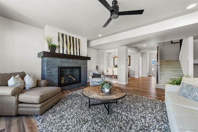 living area featuring recessed lighting, stairway, wood finished floors, and a fireplace