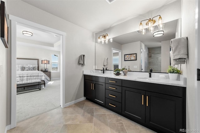 ensuite bathroom with ensuite bathroom, a sink, baseboards, double vanity, and tiled shower