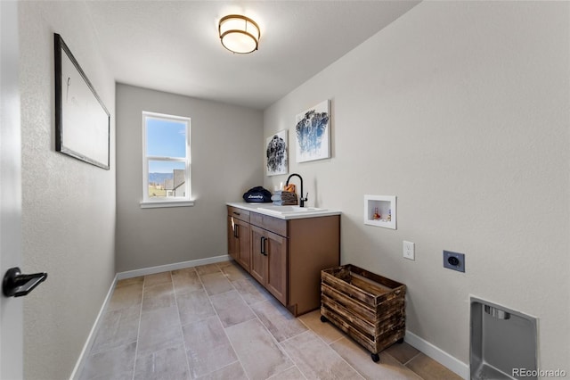 clothes washing area with hookup for a washing machine, hookup for an electric dryer, baseboards, and a sink