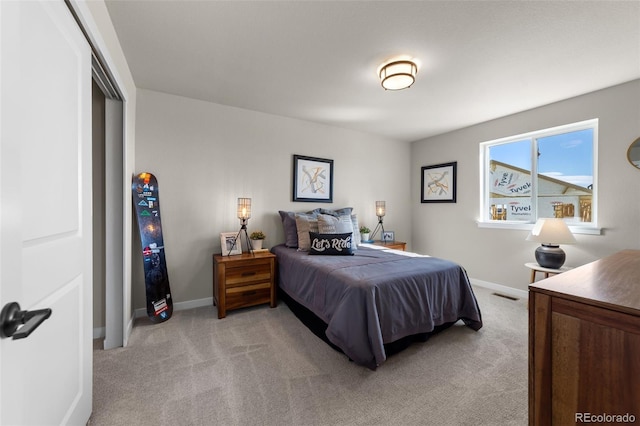 bedroom with visible vents, baseboards, and light carpet