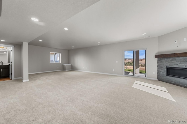 unfurnished living room featuring light carpet and baseboards