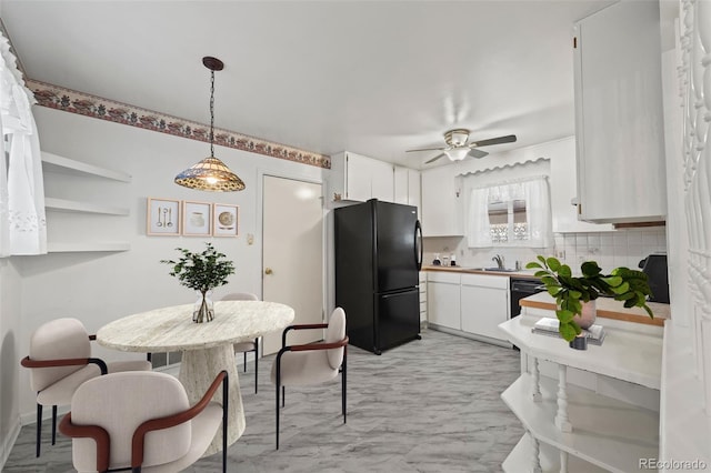 343 Melody Dr, Northglenn, CO 80260 - kitchen with freestanding refrigerator, ceiling fan, a sink, white cabinetry, and decorative backsplash