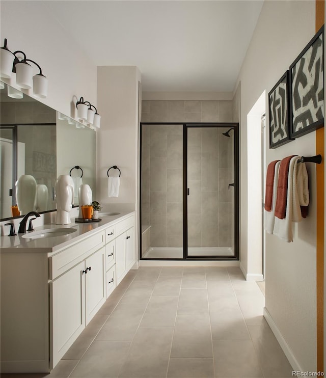 bathroom featuring a shower stall, tile patterned flooring, double vanity, and baseboards
