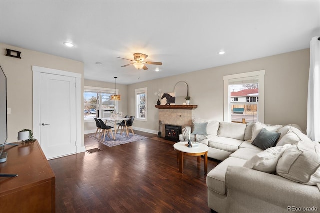 living room featuring ceiling fan and dark hardwood / wood-style flooring