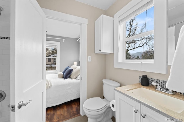 bathroom with vanity, hardwood / wood-style floors, tasteful backsplash, and toilet