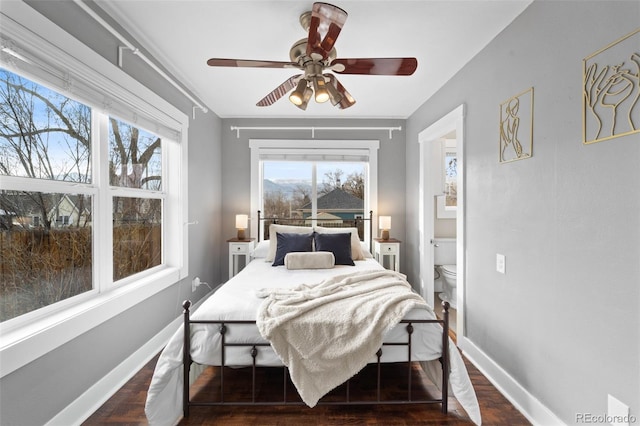 bedroom with ceiling fan, ensuite bath, and dark hardwood / wood-style floors