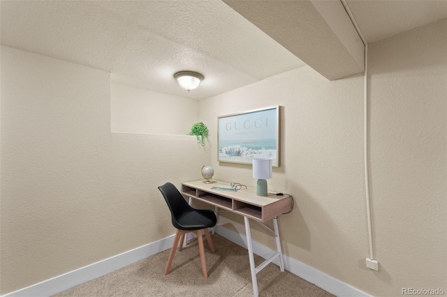 carpeted office featuring a textured ceiling