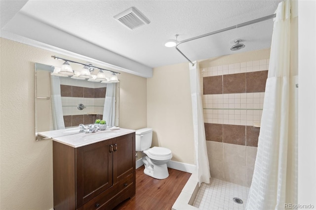 bathroom with toilet, wood-type flooring, a textured ceiling, vanity, and curtained shower