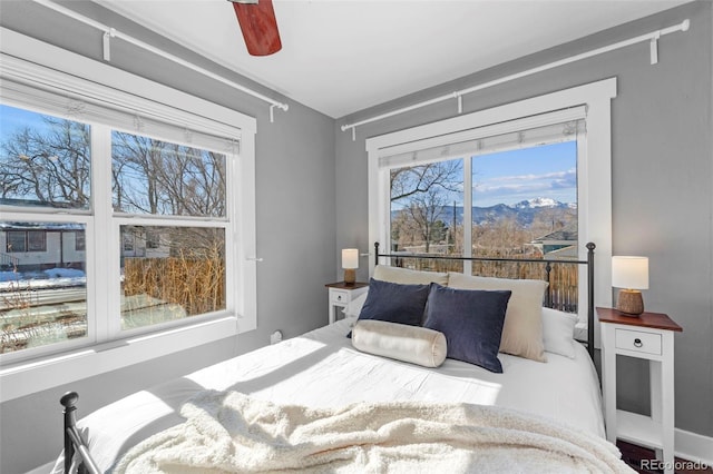 bedroom featuring ceiling fan and a mountain view