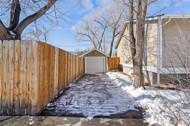 snowy yard with a garage and an outdoor structure