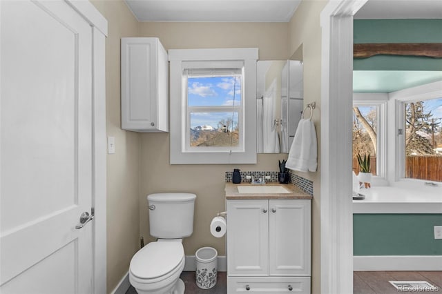 bathroom with vanity, a healthy amount of sunlight, tile patterned floors, and toilet