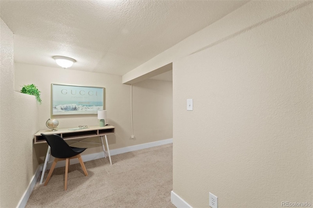 carpeted home office featuring a textured ceiling