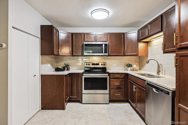 650 S Alton Way Unit 10A, Denver, CO 80247 - kitchen with appliances with stainless steel finishes, a sink, decorative backsplash, and light stone counters