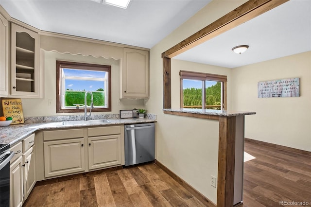 kitchen featuring dishwasher, sink, dark hardwood / wood-style floors, and cream cabinetry