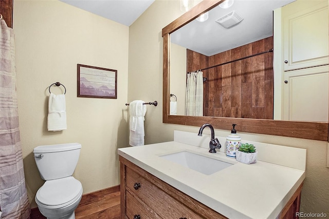 bathroom featuring vanity, hardwood / wood-style floors, and toilet