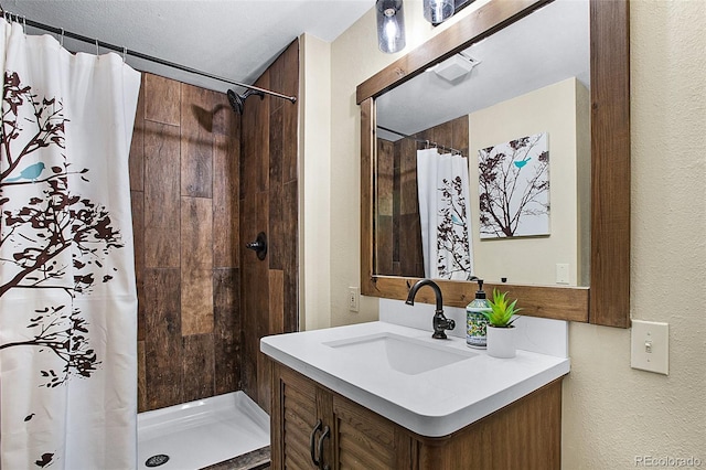 bathroom featuring vanity, a textured ceiling, and a shower with curtain