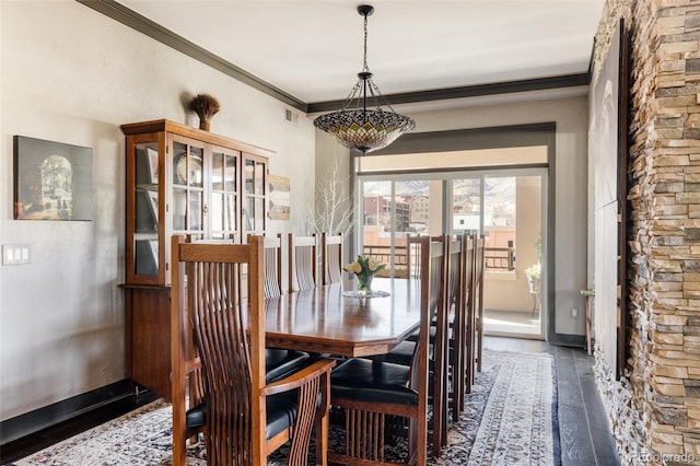 dining area featuring baseboards, wood finished floors, visible vents, and ornamental molding