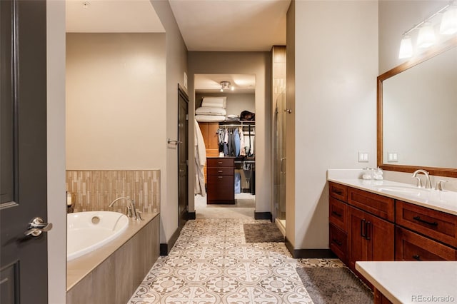 bathroom with vanity, a shower stall, a spacious closet, tile patterned floors, and a bath