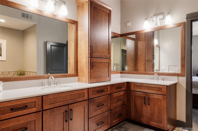 bathroom with double vanity, visible vents, and a sink