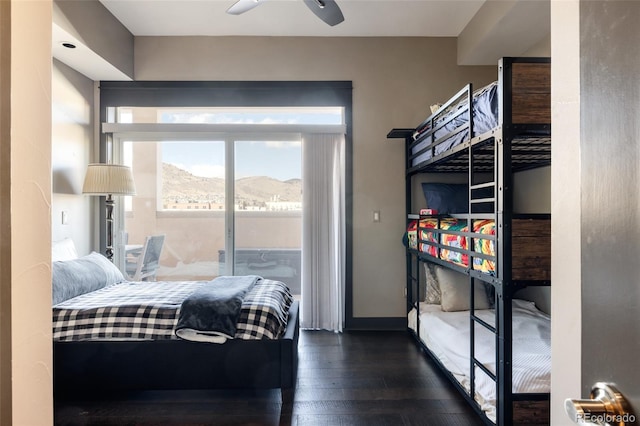 bedroom with dark wood-style flooring, a mountain view, baseboards, and access to outside