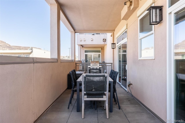 view of patio with area for grilling and a balcony