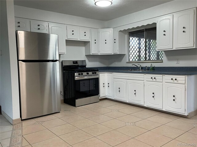 207 Autobee Ln, Avondale, CO 81022 - kitchen with appliances with stainless steel finishes, dark countertops, a sink, white cabinets, and light tile patterned floors