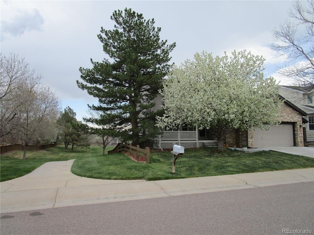 10522 Stoneflower Dr, Parker, CO 80134 - obstructed view of property with stone siding, a front lawn, driveway, and an attached garage