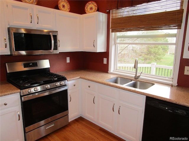 10522 Stoneflower Dr, Parker, CO 80134 - kitchen featuring stainless steel appliances, a sink, light countertops, white cabinets, and light wood-style flooring