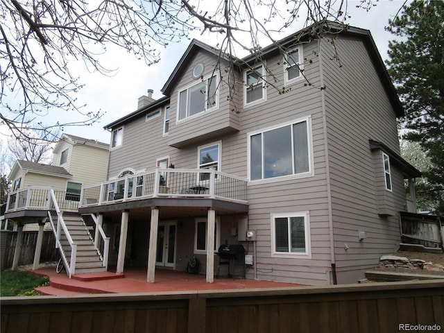 10522 Stoneflower Dr, Parker, CO 80134 - back of property featuring a deck, a chimney, stairs, and fence
