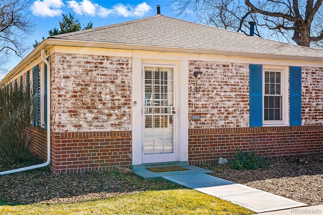1257 Locust St, Denver, CO 80220 - view of exterior entry with brick siding and a shingled roof