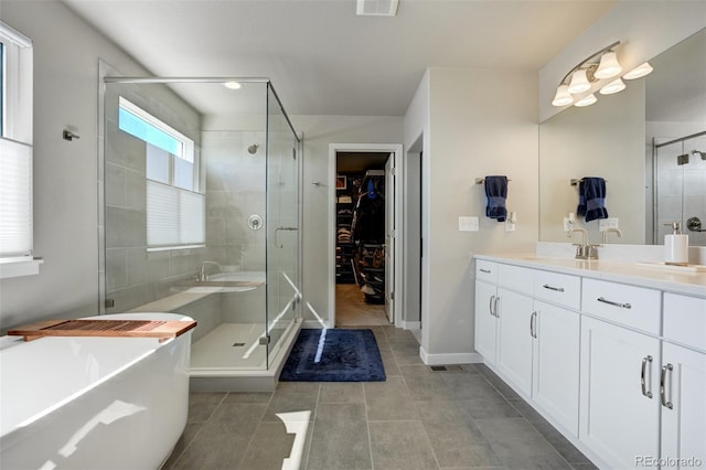 10024 Waterton Canyon Way, Colorado Springs, CO 80924 - full bathroom with a shower stall, a freestanding tub, vanity, a walk in closet, and tile patterned floors