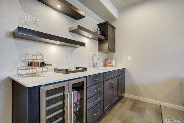 10024 Waterton Canyon Way, Colorado Springs, CO 80924 - bar featuring baseboards, indoor wet bar, a sink, light wood-type flooring, and wine cooler