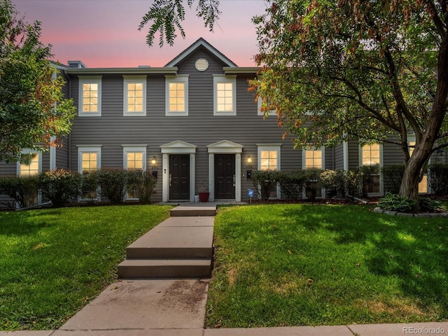 colonial home featuring a lawn