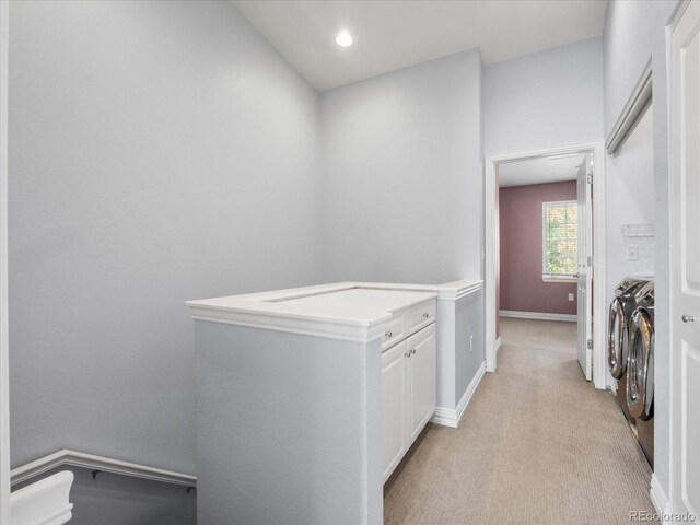 clothes washing area with washer and clothes dryer and light carpet