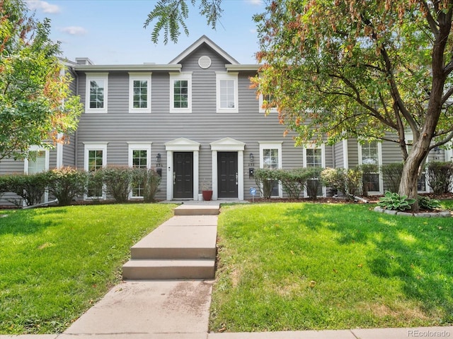 colonial inspired home featuring a front lawn