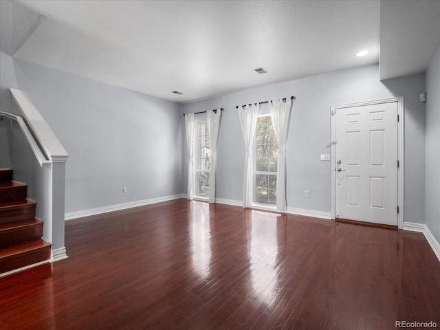 unfurnished living room featuring recessed lighting, wood finished floors, visible vents, baseboards, and stairs